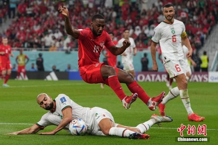 北京时间12月1日，卡塔尔世界杯小组赛F组第3轮，加拿大队对阵摩洛哥队。开局第4分钟齐耶赫就帮助摩洛哥队取得领先，随后恩内西里破门，阿盖德将对方的传中球挡入自家球门。最终摩洛哥队2:1战胜加拿大队，以小组第一的身份晋级16强。图为摩洛哥队球员(白)铲球。中新社记者 崔楠 摄